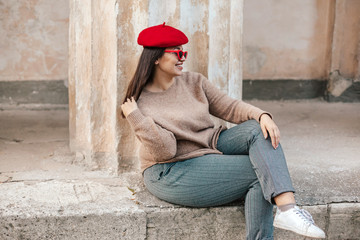 Plus zise model wearing sweater and beret posing on the city street