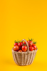 Basket with tomatoes on a yellow background.
