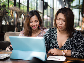 Asian women using tablet in cafe together, lifestyle concept.