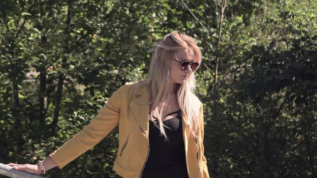 Pretty blonde in sunglasses and a yellow jacket