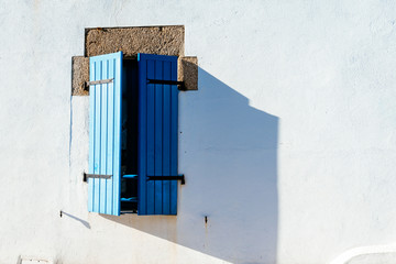 Old window with wooden blue painted shutters