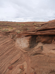 Lake Powell and arizona desert landscape with layered  red rock strata and distant cars on the...