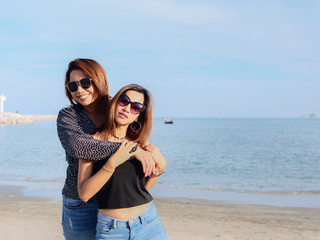 Asian lesbian couple hugging together on the beach, lifestyle concept.