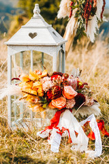 Composition of autumn flowers in bouquet on lantern background