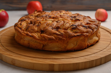Cornish apple pie top view on rustic style white background. Next to three apples. Copy space for your text