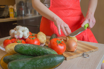 woman hands cutting vegetables on kitchen blackboard. Healthy food. Woman preparing vegetables