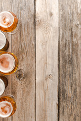 Overhead shot of beer glasses on wooden table.