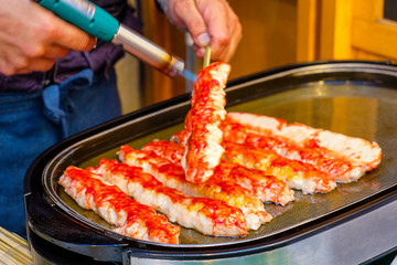 Fresh tender meat from the legs of a king crab blow torch in Tsukiji Market, Tokyo