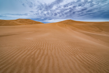 Fototapeta na wymiar Storm clouds over sand dunes in the desert