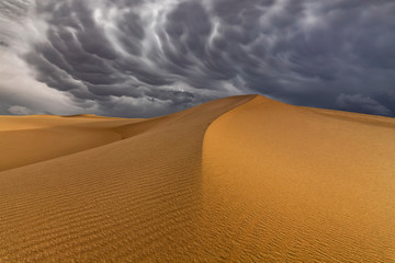 Storm clouds over sand dunes in the desert