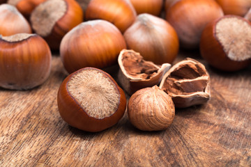 close up of hazelnuts on wooden table .