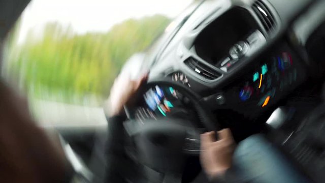 Dangerous driving. Man driving a car on the road in sunny weather and loses control during the ride