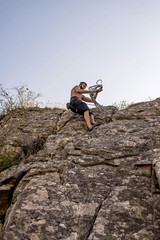 Rock climber climbing up a rock, extreme sport concept.