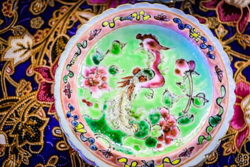 colourful peranakan small dishes on a colourful batik table cloth with typical peranakan cookies