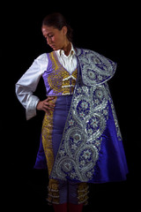 Fototapeta premium Woman bullfighter posing with capote walk purple with hand on waist