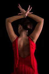 Flamenco dancer on your back with your arms crossed up passionate in black background