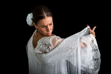 Flamenco dancer with white dress and hands crossed up on his back on black background