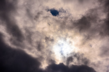 Beautiful puffy clouds with sun beams against blue skies.  