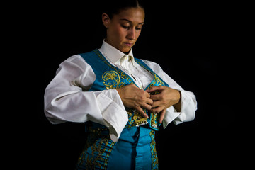 Woman bullfighter by dressing with vest on your back on a black background
