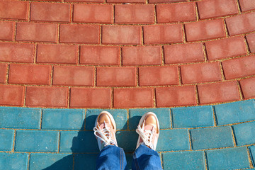 human foots in shoes standing on the pavement tiles