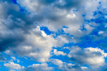 Beautiful puffy clouds with sun beams against blue skies.  