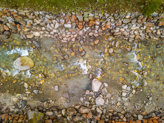 Aerial view of riverbed in Switzerland. Top view of water flowing downstream.