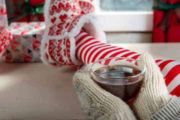 Girl in socks enjoying a winter time drinking cup of tea