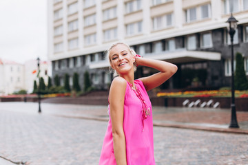 Fototapeta premium Fashionable beautiful young blondie woman posing in trendy fashionable costume in pink colors. Beauty, fashuon, modeling concept