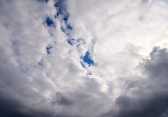 Beautiful puffy clouds with sun beams against blue skies.  