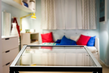 Glass table top with blurred luxury home interior. Table background with empty space for products and decorations.