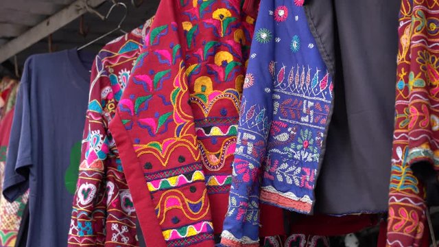 Assortment of colorful clothes for sale in local street market in Udaipur, Rajasthan, India. Close up