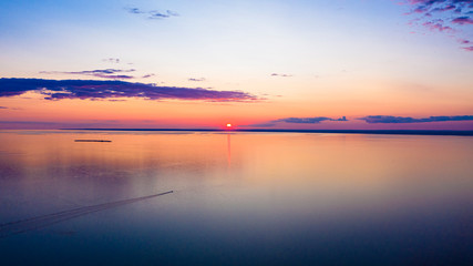 Dramatic gold sunset with evening sky clouds over the lake