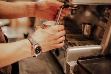 Barista make coffee latte art with espresso machine in cafe vintage instagram filter. Barista male hands make fresh flavored coffee close-up. Vintage coffee machine and hands professional barista.  