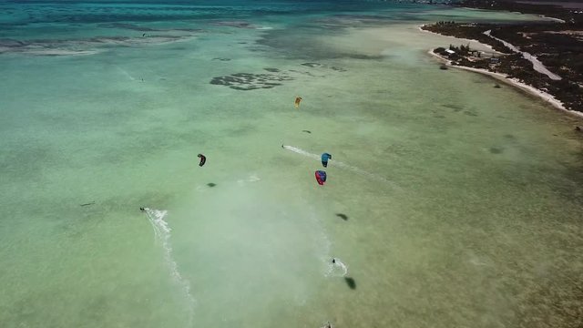 Aerial of Kite Surfers in Tropical Blue Ocean with White Sand Beach. Anegada, Caribbean.