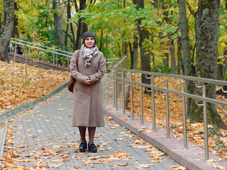 Fototapeta premium Beautiful brunette woman in autumn yellow park