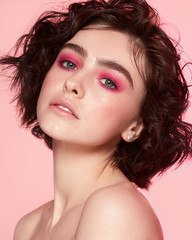 young girl with pink smoky eyes pink background