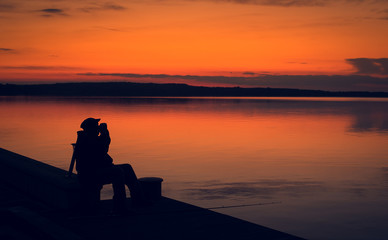 Fototapeta premium Fisher man fishing in sunset.