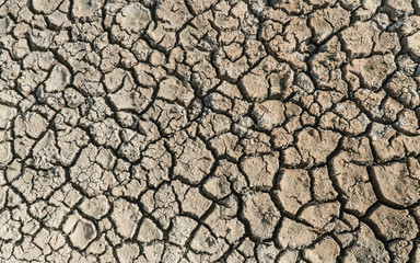 Dried cracked desert sand pattern texture. Barren terrain, with rough, scarcity concepts. Abstract...