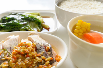 side view spicy fish and vegetable and maize soup and rice