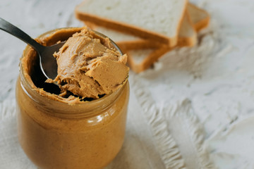 thick peanut butter in a jar close-up. Healthy eating.