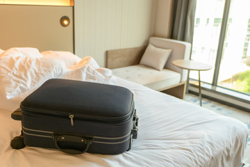 blue luggage on the bed of a hotel room