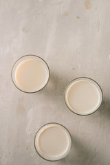 Three glasses of milk on table. Top view.
