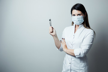 Portrait of female dentist .She standing in her dentist office. Female dentist wearing a white robe