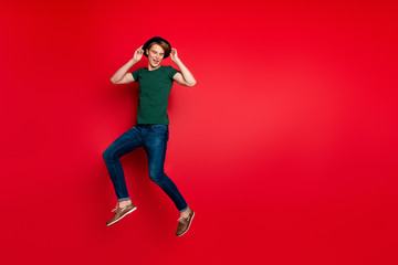 Full size photo of funny funky guy in blue velvet headwear jump have free time on spring holidays wear denim jeans clothing sneakers isolated over red color background