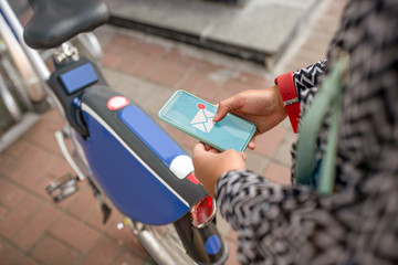 Close up of young woman checking her e-mail on smartphone