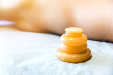 Stones for massage and recovery of health. Yellow jade on the massage table column. © broniktav