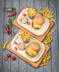 Fast food dish top view. Meat burger, potato chips and wedges. Take away composition. French fries, hamburger, mayonnaise and ketchup sauces on wood