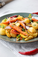 warm salad of baked potatoes and carrots with red onions, spices and tomatoes