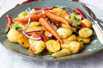 warm salad of baked potatoes and carrots with red onions, spices and tomatoes