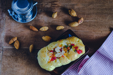 Mixed fruit bread with almond flakes on color wood background,food concept.
